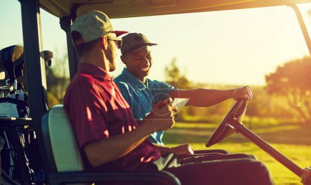 Téléchargez les photos : Tu ferais mieux de lire toutes les règles cette fois... deux golfeurs en chariot sur un terrain de golf - en image libre de droit