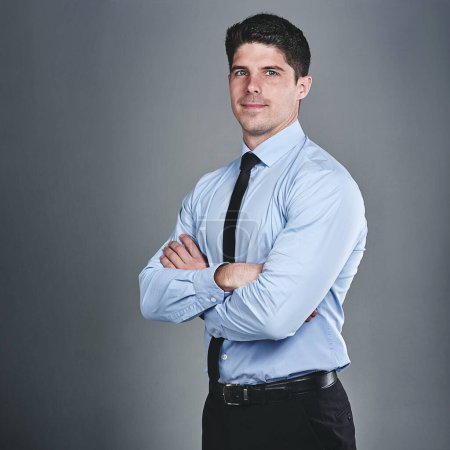 Photo for Achieving the impossible is a thrill for me. Studio portrait of a young businessman posing against a grey background - Royalty Free Image