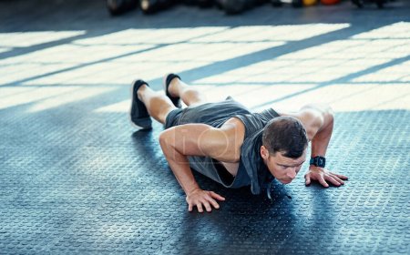 Photo for It takes time but dont give up. a young man doing push ups in a gym - Royalty Free Image