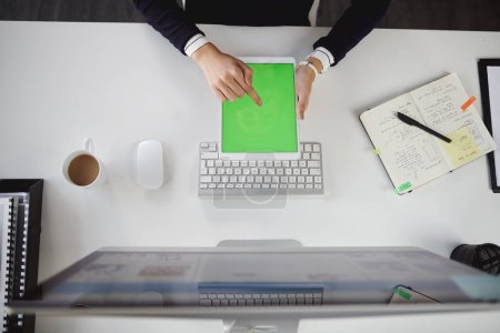Foto de ¿Dónde estaríamos sin tecnología? Foto aérea de una joven empresaria irreconocible sentada en su escritorio y usando su tableta en una oficina moderna - Imagen libre de derechos