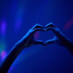 Lights, heart hands of fan at party or concert at night, stadium lighting and bokeh with mock up. Music festival, love hand sign in silhouette and live performance show with neon light in arena space.