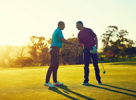 Téléchargez les photos : La confiance est le facteur le plus important dans ce jeu. deux golfeurs serrant la main sur le terrain de golf - en image libre de droit