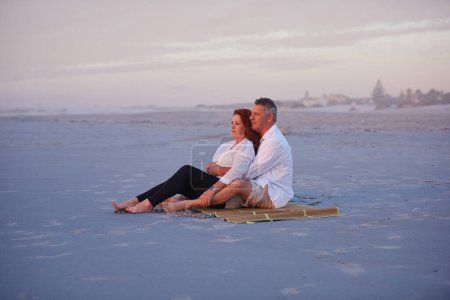 Téléchargez les photos : Faciliter la retraite avec des vacances à la plage. un couple d'âge mûr se relaxant ensemble sur la plage - en image libre de droit