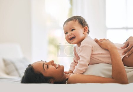 Photo for Mother lying, embrace newborn baby and bed with smile, care or happiness in morning with love, bond or excited face. Young mom, kid and happy in bedroom, family home or holding with pride in sunshine. - Royalty Free Image