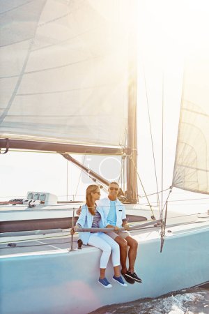Photo for Couple, boat and adventure at sea for holiday during summer to relax on luxury or rich cruise. Ocean, vacation and people on yacht for outdoor travel and freedom to enjoy the sunshine together - Royalty Free Image