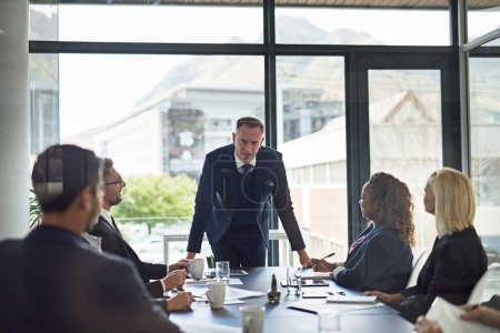 Photo for Presentation, man speaker with coworkers and in business meeting in a conference room of their workplace. Brainstorming or planning, ideas or data review and colleagues together in modern office. - Royalty Free Image