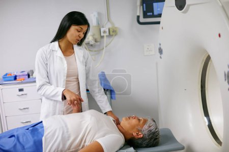 Téléchargez les photos : Mri, le médecin et la femme tenant la main du patient à l'hôpital avant de scanner dans la machine. scan Ct, confort et professionnel de la santé avec la personne âgée de sexe féminin dans le test de radiologie pour les soins de santé en clinique - en image libre de droit