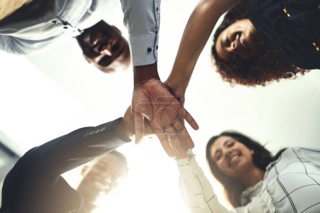 Photo for Teamwork is inevitable towards our success. Closeup shot of a group of businesspeople joining their hands together in a huddle - Royalty Free Image