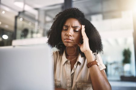 Foto de Necesito tomar el control de este estrés. una joven mujer de negocios mirando estresada en su escritorio en una oficina moderna - Imagen libre de derechos