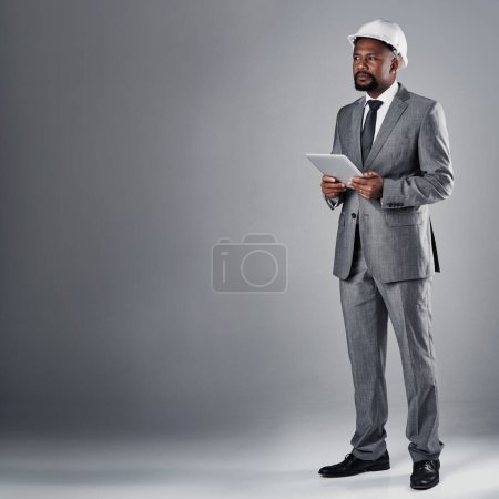 Photo for If you can dream it, he can build it. a well-dressed civil engineer using his tablet while standing in the studio - Royalty Free Image