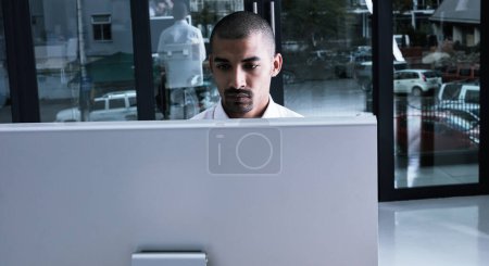 Photo for Stay connected, stay productive. a young businessman using a computer at night in a modern office - Royalty Free Image