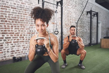 Photo for Exercise benefits more than just your body. two sporty young people using kettlebells while working out at the gym - Royalty Free Image