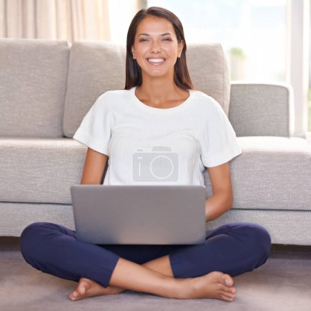 Foto de Sonrisa, portátil y retrato de la mujer en el piso de casa con Internet para la transmisión en línea. Mujer feliz relajarse en el salón para el trabajo remoto, el estudio y la investigación o correo electrónico para las redes sociales o blog. - Imagen libre de derechos