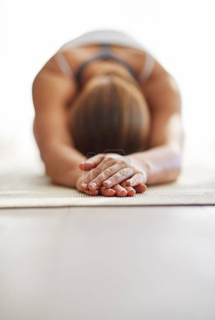 Foto de Mujer, manos y cuerpo de estiramiento en yoga sobre alfombra de piso para bienestar espiritual, ejercicio o entrenamiento zen en casa. Persona femenina o yogui en el estiramiento de calentamiento para la aptitud física o la salud mental en el espacio de maqueta. - Imagen libre de derechos