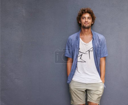Photo for Confidence, casual and male model by a wall with mockup space with a hipster, cool and stylish outfit. Happy, positive and handsome man with trendy style or fashion by a gray background with mock up - Royalty Free Image
