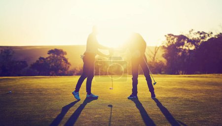 Téléchargez les photos : La chance est ce qui arrive quand la préparation rencontre l'occasion. deux golfeurs serrant la main sur le terrain de golf - en image libre de droit