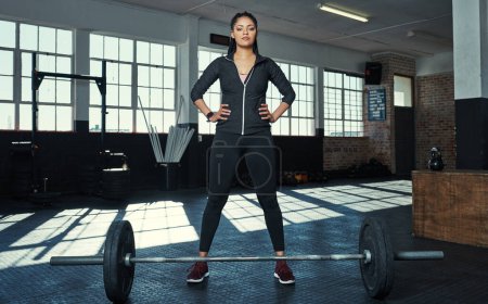 Téléchargez les photos : Engagez-vous à lever. une jeune femme se préparant à soulever des poids dans une salle de gym - en image libre de droit