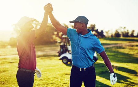 Téléchargez les photos : Pratiquez la victoire tous les jours. deux golfeurs de haute-cinq sur un terrain de golf - en image libre de droit