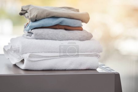 Photo for Home, clothes on a washing machine and laundry day with a lens flare. Cleaning or hygiene, appliances or mockup space and folded clean pile of clothing on a wash dryer at a house for housework. - Royalty Free Image