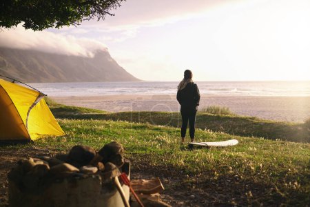 Téléchargez les photos : En voyage de surf en solo. une jeune femme séduisante campant à son spot de surf préféré - en image libre de droit