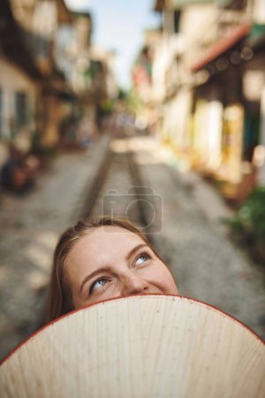 Foto de Viajar significa aventura. una mujer sosteniendo un sombrero cónico delante de su cara - Imagen libre de derechos