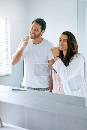 Téléchargez les photos : Nous n'avons aucun problème à partager notre espace personnel. un couple se brossant les dents dans la salle de bain à la maison ensemble - en image libre de droit