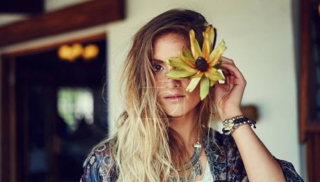 Foto de Pelo hippie, no importa. Retrato de una joven de espíritu libre posando en una tienda de carretera con una flor - Imagen libre de derechos