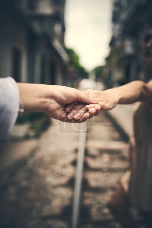 Téléchargez les photos : Prends ma main et prends bien le monde ensemble. un couple se tenant la main en marchant sur les voies ferrées au Vietnam - en image libre de droit