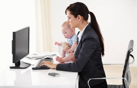 Téléchargez les photos : Travail à distance, femme d'affaires avec son bébé et tapant sur le clavier avec PC à son bureau dans un bureau. Technologie, engagement et mère avec son enfant écrivant un courriel avec son ordinateur à sa maison. - en image libre de droit