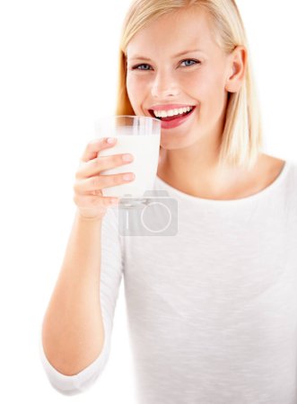 Téléchargez les photos : Portrait, lait et sourire avec une femme buvant dans un verre en studio isolé sur fond blanc. Santé, nutrition et calcium avec une jeune femme heureuse dégustant une boisson pour vitamines ou minéraux. - en image libre de droit