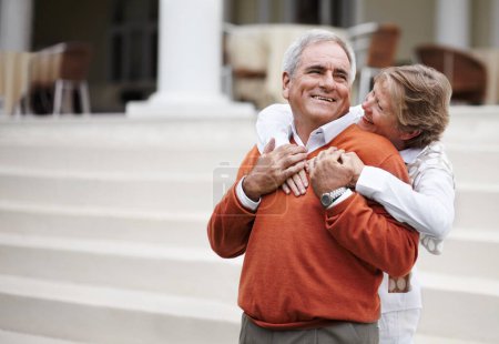 Photo for Hug, retirement and an old couple on hotel steps for travel, vacation or tourism in luxury accommodation. Love, relax or hospitality with a senior man and woman hugging on the staircase of a resort. - Royalty Free Image