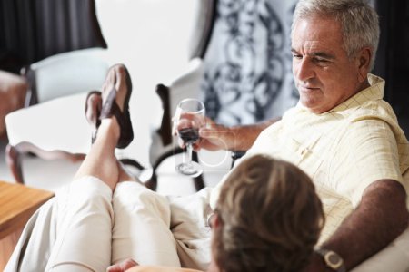 Photo for Relax, love and an old couple drinking wine in their hotel room while on holiday or vacation together. Toast, sofa or retirement with a senior man and woman bonding at a luxury resort for romance. - Royalty Free Image