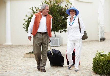 Foto de Viaje, maleta y pareja de ancianos caminando de vacaciones en un lugar de vacaciones felices en la jubilación juntos en un hotel. Bolsa, sonrisa y personas mayores en un viaje o hombre y mujer caminan en felicidad. - Imagen libre de derechos