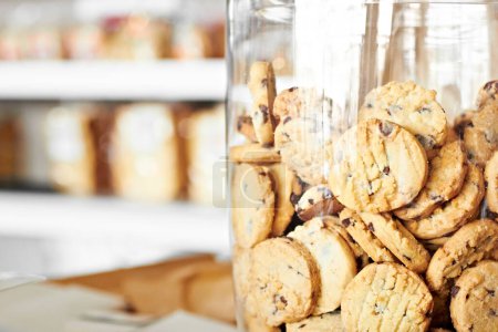 Photo for Dessert, bakery and closeup of jar with cookies for coffee shop, sugar and junk food. Cooking, chocolate and nutrition with oatmeal biscuit in container in cafe for snack, breakfast and pastry. - Royalty Free Image