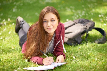 Photo for Woman, student and grass for writing, portrait or planning at university, campus or park for studying. Girl, book and pen for education, learning or brainstorming ideas on lawn at college in sunshine. - Royalty Free Image