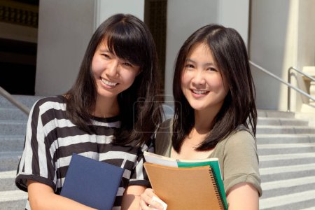 Photo for College, happy and portrait of girl friends with scholarship standing outdoor on campus for education. Knowledge, smile and Japanese female university students by a school building in the city - Royalty Free Image
