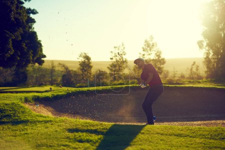 Photo for Theres no bunker he cant beat. a young man hitting the ball out of the bunker during a round of golf - Royalty Free Image