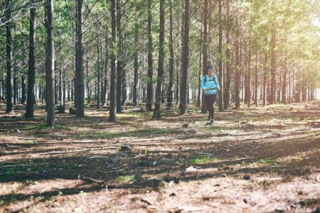 Photo for Fitness is about being better than you were yesterday. Full length shot of an athletic young woman out for a jog in the woods - Royalty Free Image