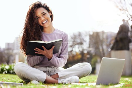 Photo for Woman on lawn, laptop and notebook, college student on campus and studying course material and education. Happy female person in outdoor portrait, learn and study online notes on pc with scholarship. - Royalty Free Image