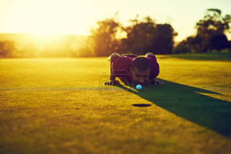 Foto de Tómalo antes de que lo hunda. un joven mirando el putt durante una ronda de golf - Imagen libre de derechos