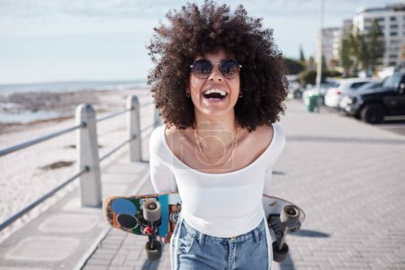 Téléchargez les photos : Femme, heureuse et en plein air avec une planche à roulettes pour voyager, l'aventure et la liberté sur une route de plage. Visage de la personne africaine comique rire sur la promenade pour des vacances tropicales ou patiner avec des lunettes de soleil à Miami. - en image libre de droit