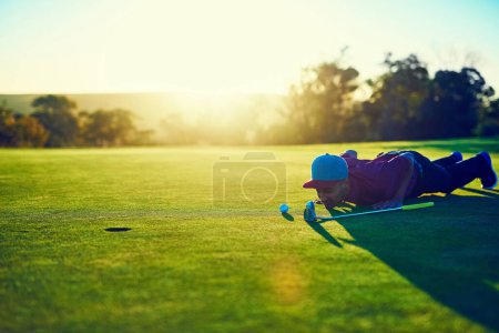 Foto de Lo logrará o se lo perderá. un joven mirando el putt durante una ronda de golf - Imagen libre de derechos