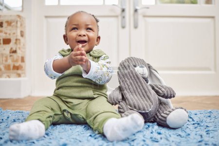 Photo for Smile, baby and black child clapping in home, having fun or enjoying teddy bear. African newborn, children and toddler, kid and young infant play, happy or applause for childhood development in house. - Royalty Free Image