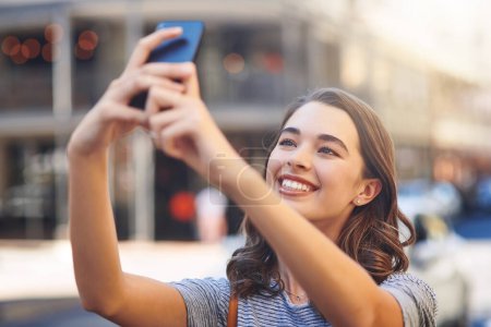 Photo for Selfies in the city. an attractive young woman taking selfies while spending her day out in the city - Royalty Free Image