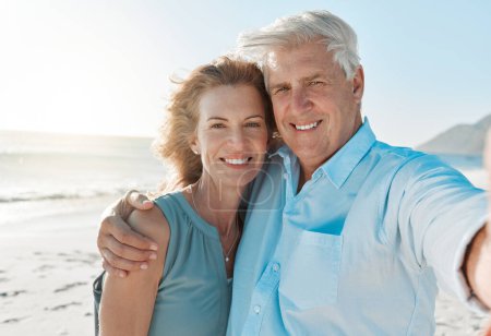 Photo for Senior, couple and selfie at the beach with portrait for happiness on holiday for the weekend. Mature, woman and man hug at the ocean for closeup and smile in the outdoor on vacation for retirement - Royalty Free Image