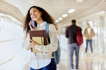 Photo for College student, books and woman talking on phone at school for scholarship. Happy african person with backpack and smartphone connection on a call at university for education, learning and knowledge. - Royalty Free Image