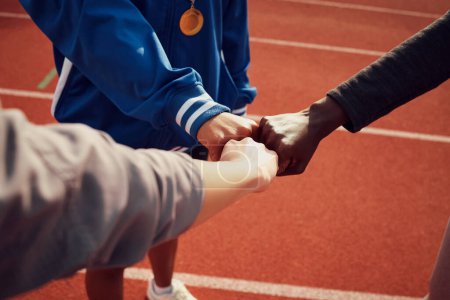 Photo for People, diversity and fist bump in fitness for unity, trust or support together on stadium track. Hands of group touching fists in team building for sports motivation, teamwork or goals outdoors. - Royalty Free Image