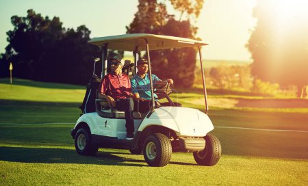 Téléchargez les photos : Au premier tee-shirt. deux golfeurs en chariot sur un terrain de golf - en image libre de droit