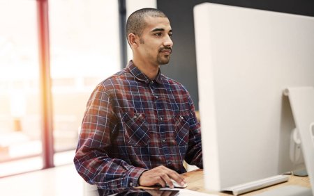 Foto de La tecnología ayuda a aumentar el ritmo de hacer negocios. un joven empresario que trabaja en una computadora en una oficina - Imagen libre de derechos
