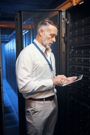 Photo for Connect with the best. a mature man using a digital tablet while working in a server room - Royalty Free Image